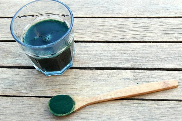 copo e colher com a substância spirulina