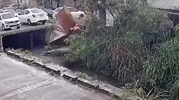 Quintal desaba em canal e mulher é levada pela correnteza no RJ. Vídeo