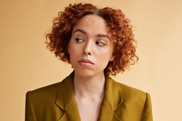 foto colorida de mulher desviando o olhar ao falar