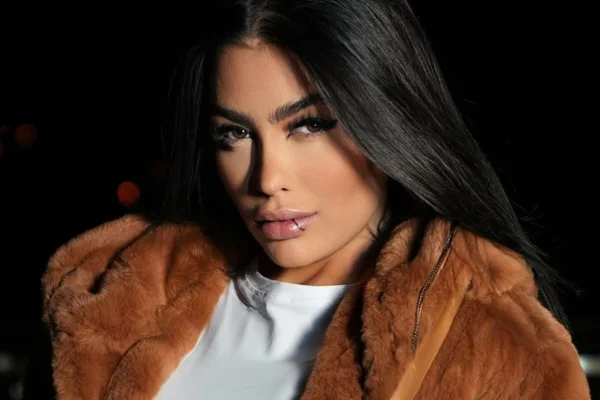MC Mirella posa de camisa branca e casaco marrom - Metrópoles