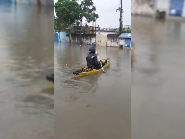 Morador usa caiaque para andar em rua alagada em SP