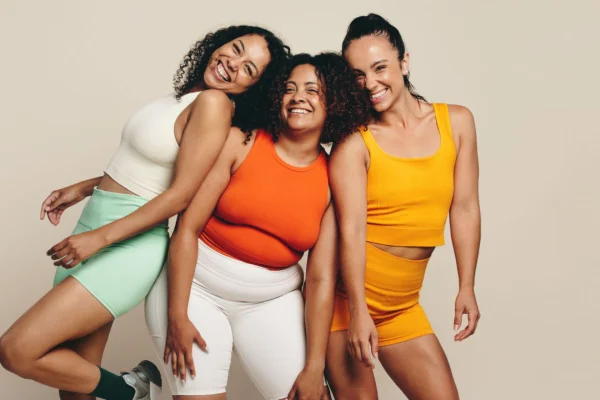 3 mulheres sorridentes com roupas coloridas