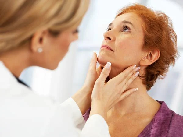 Imagem de médica examinando pescoço de mulher idosa - Metrópoles
