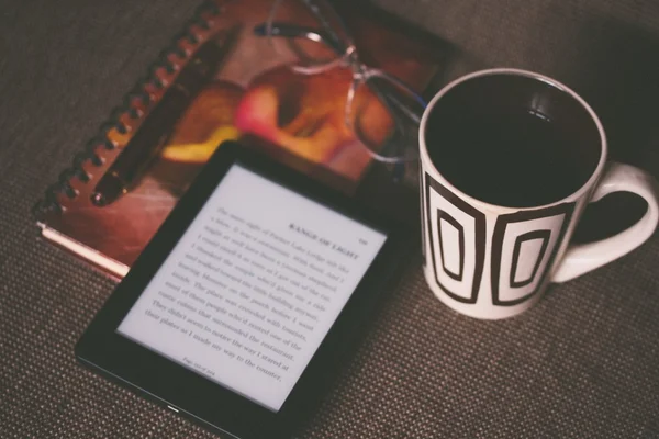 Kindle, caderno, caneca com café