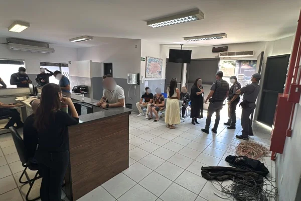 Foto colorida mostra plantão de delegacia cheio de policiais e pessoas, no interior de São Paulo.