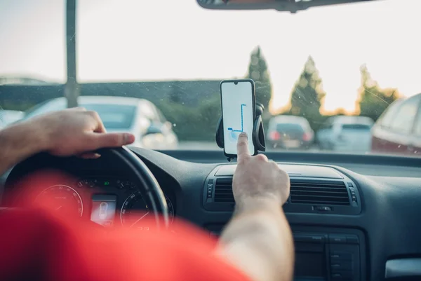 foto mostra um homem dirigindo um carro em uma corrido por aplicativo
