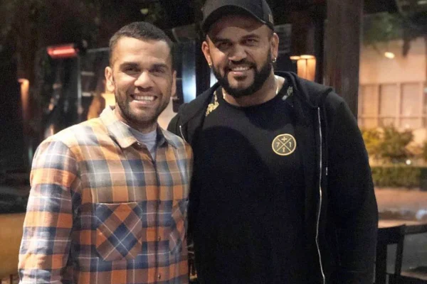 Daniel Alves e o irmão Ney Alves posam juntos e sorridentes - Metrópoles