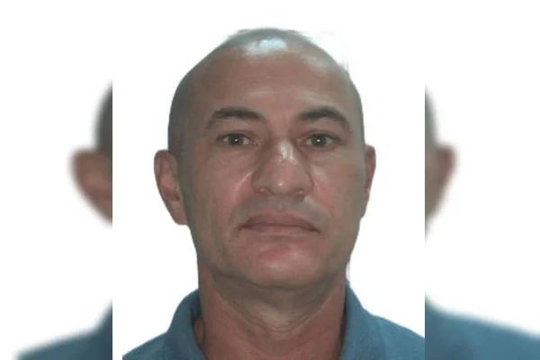 homem branco de camisa azul e sério