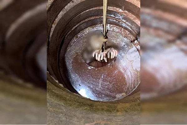 Jovem sendo alçado de cisterna com as mãos amarradas