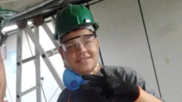 Em foto colorida ajudante de pedreiro, morto pela PM, sorri usando capacete verde, óculos de proteção e camiseta preta - Metrópoles
