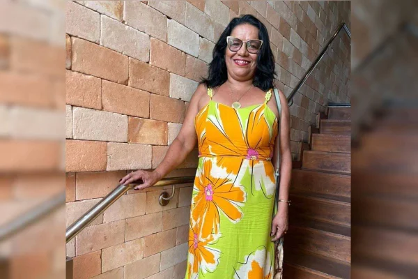 Mulher de óulos com vestido laranja e verde florido