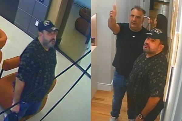 Homem branco, com barba preta, boné e camiseta preta observa ambiente fechado, junto com outro homem, branco e sem barba, de camiseta preta - Metrópoles