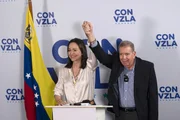 A líder da oposição Maria Corina Machado levanta a mão do candidato da oposição Edmundo González durante uma entrevista coletiva um dia após a eleição presidencial de 29 de julho de 2024 em Caracas, Venezuela
