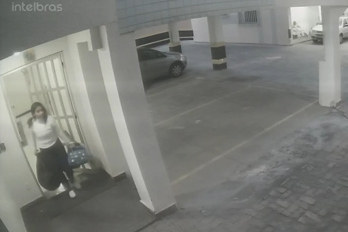 Diarista saindo da casa de Raphaella carregando bolsas Diarista saindo da casa de Raphaella carregando bolsas