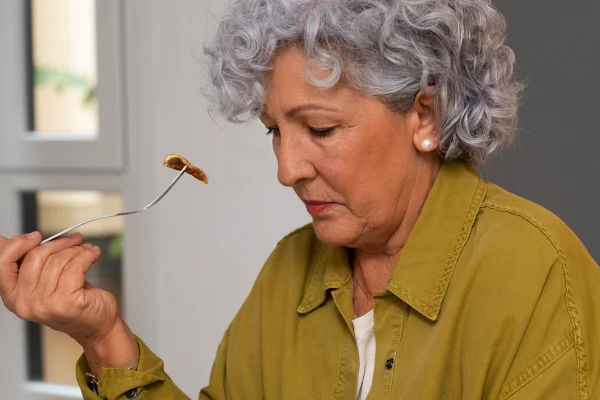 Foto coloridade de mulher com gardo comendo algo saudável - Metrópoles.