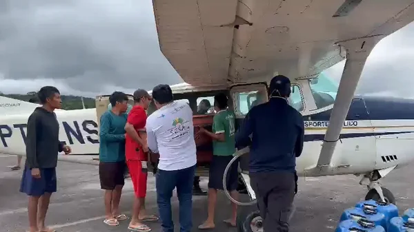 Caixões sendo tirados do avião por indígenas em Surucucu — Foto: Divulgação/Condisi-YY