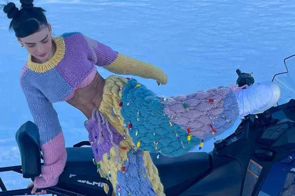 Na imagem com cor, uma mulher branca com cabelo preto preso usando um conjunto de tricot candy color - Metrópoles