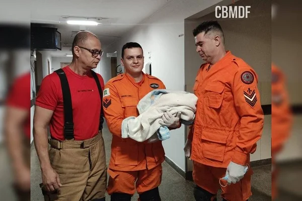 Bombeiros que salvaram a criança, com o menino no colo
