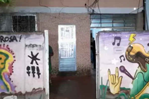 Imagem colorida de fachada de pousada em Perdizes onde homem foi encontrado morto. Na imagem também aparecem muros pichados - Metrópoles