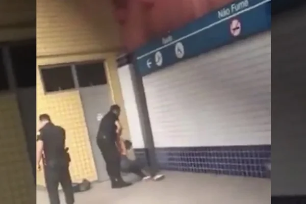 Dois agentes de segurança levantam homem que estava no chão após ser agredido em estação de metrô em BH
