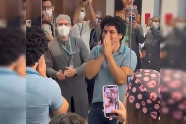 Homem com as mãos no rosto, incrédulo, de camisa azul.