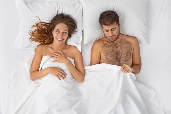 Foto colorida de mulher e homem deitados em cama