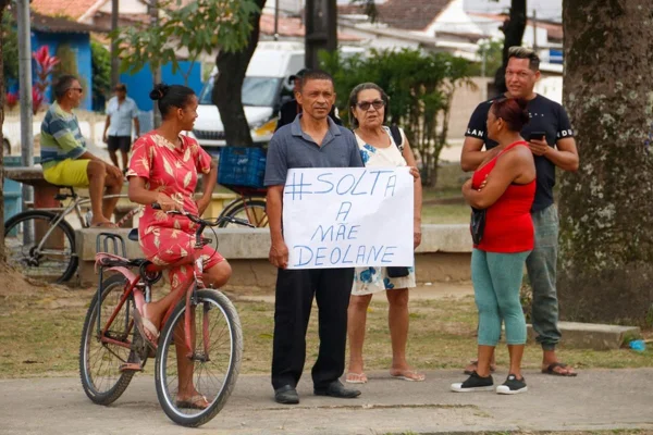Imagem colorida de fãs de Deolane ficam com cartazes em frente ao presídio pedindo liberação da advogada - Metrópoles