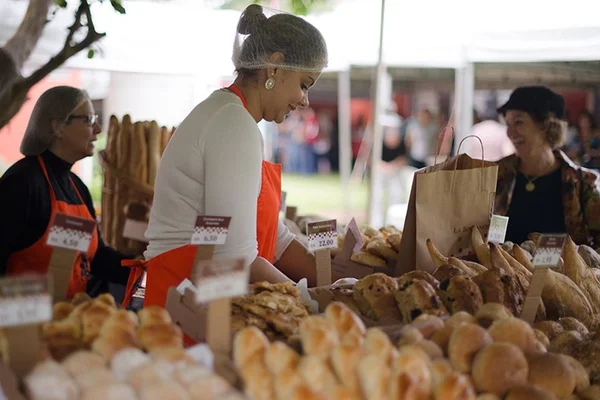 Mulher vende pães da La Boulangerie no Festival da Francofonia