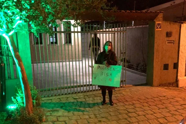 Idosa segura cartaz após carreata de aniversário