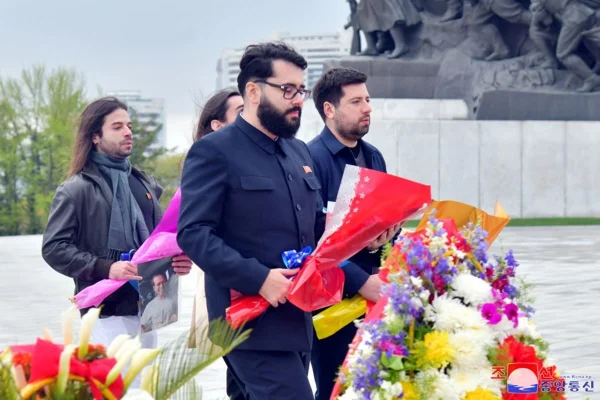 Imagem colorida mostra brasileiros colocando flores no túmulo do primeiro presidente da Coreia do Norte - Metrópoles