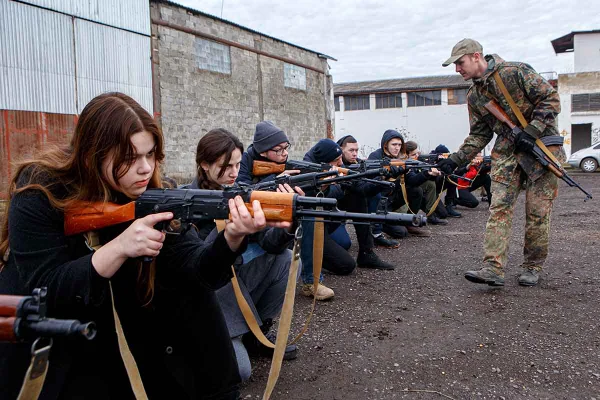 Um instrutor ensina às pessoas a posição ajoelhada durante um exercício militar para civis realizado pelo Movimento dos Veteranos de Zakarpattia - Metrópoles