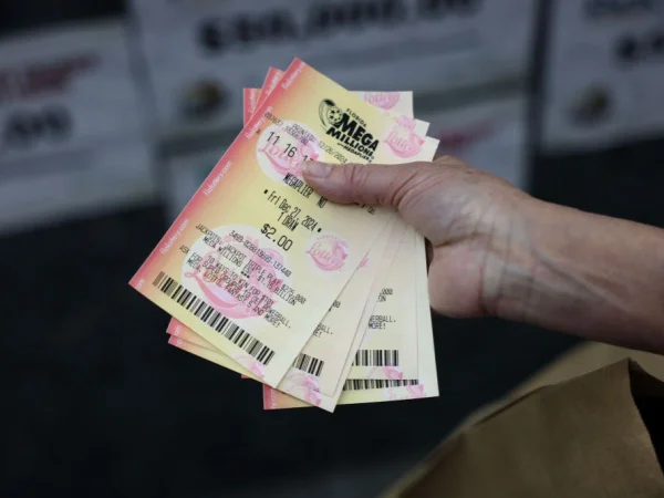 Foto colorida de pessoa segurando bilhetes do sorteio Mega Millions, nos EUA - Metrópoles