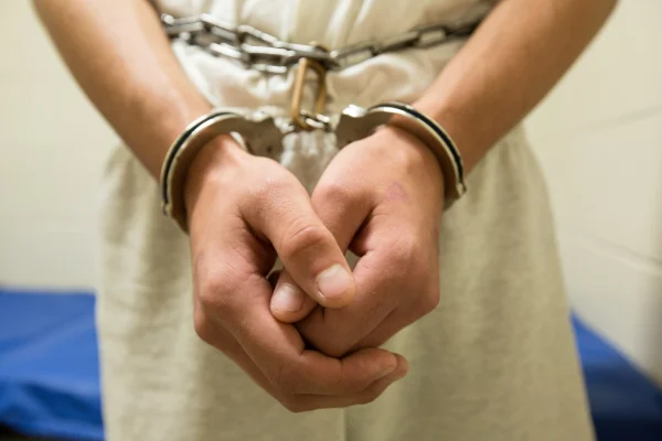 Imagem colorida de menor infrator usando algemas. Adolescente que furtou condomínios será internado, determina Justiça. - Metrópoles
