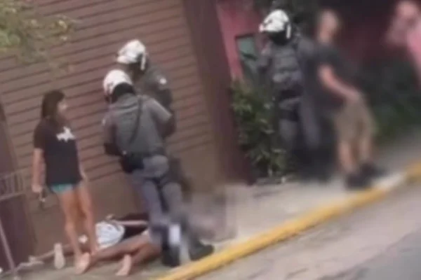 Foto colorida de guarda municipal de folga e armada com suspeitos rendidos em Jundiaí.