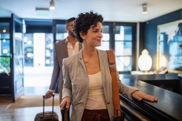 Imagem colorida de mulher chegando em um hotel