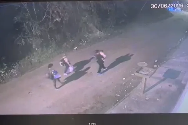 Imagem colorida de foragido suspeito de balear tenente da rota caminhando em rua de terra com a família - Metrópoles