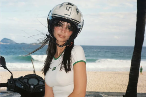na fota, modelo branca com capacete de moto em praia
