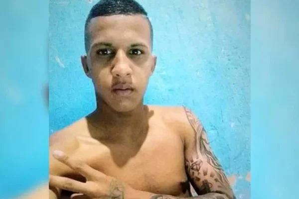Homem negro sem camisa com tatuagem no braço