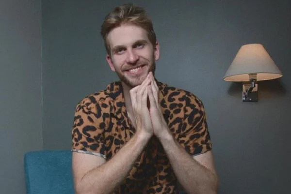 Homem sentado com blusa estampada