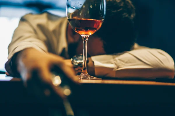 Foto colorida de homem sentado sozinho no balcão do bar, com problemas de alcoolismo - Beber álcool altera genes do cérebro ligados ao vício, aponta estudo - Metrópoles