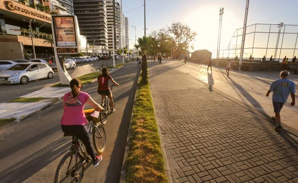 Foto colorida- pessoas caminhando e andando durante o pôr do sol-Metrópoles
