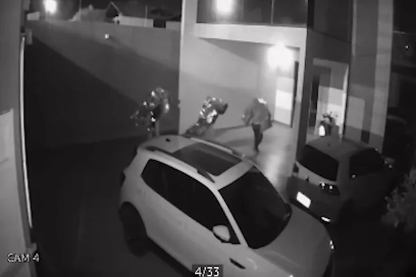 Três homens cobertos com pedaço de material brilhante vasculha residência