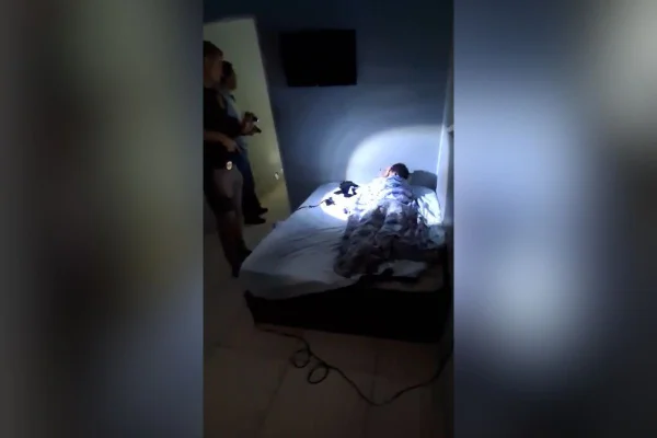 Imagem colorida mostra criminoso pego pela polícia enquanto dormia. Metrópoles