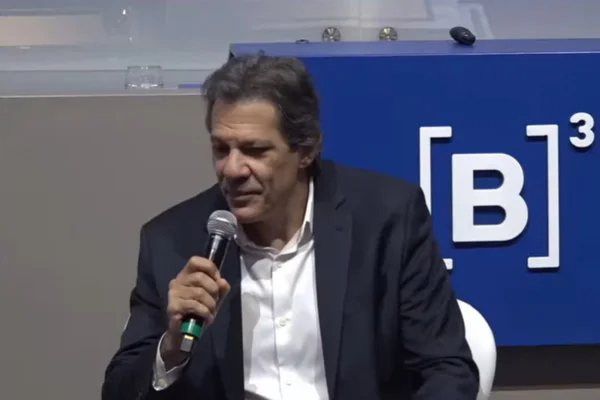 Imagem de Fernando Haddad, ministro da Fazenda, fazendo discurso com microfone na mão durante evento - Metrópoles