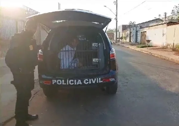 Frame de imagem colorida de um homem preso em uma viatura