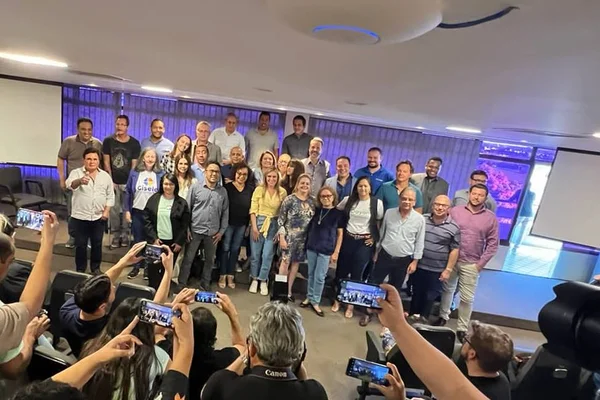 Fotografia colorida de fotógrafos tirando foto de grupo de pessoas em pé com fundo roxo