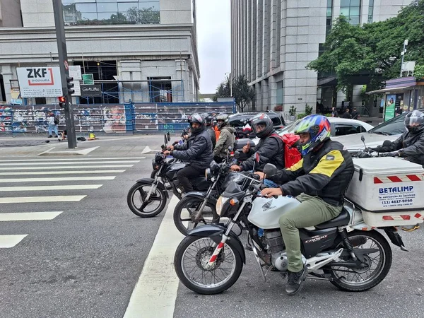 Imagem mostra motociclistas aguardando antes da faixa de pedestre - Metrópoles