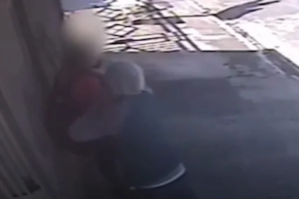 Imagem colorida de homem encapuzado atacando adolescente com uma faca. Metrópoles