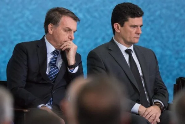 Bolsonaro e Sérgio Moro, ex-juiz e atual pré-candidato a Presidência da República. Eles usam terno escuro e camiseta branca- Metopoles