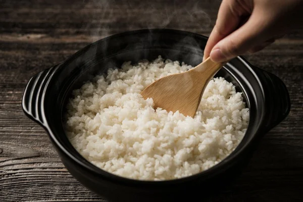 Imagem colorida de arroz na panelinha preta - Metrópoles